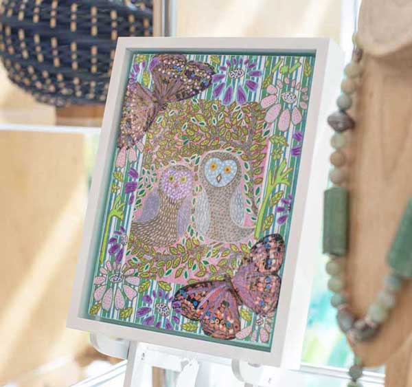 A painting accompanied by jewelry on display.