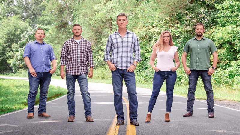 A group of people standing on the side of a road.