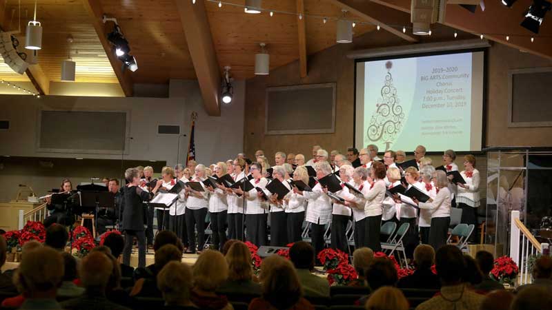 A group of people singing at a christmas concert.